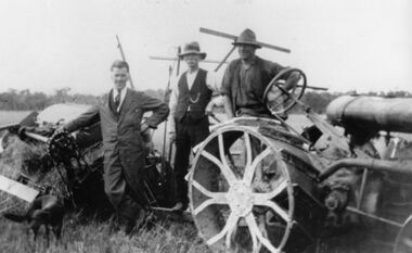 Photograph - Percy Charles Holloway (on left) and 2 other men and dog beside a tractor and binder, 1926