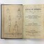 Book open showing black line drawings, by O.R Campbell, of two hands placed flat side by side and four figures in various positions for swimming and rescue. Also shows the title page with handwritten inscriptions, including possible inscription by the author.
