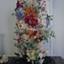 Glass dome on wooden base enclosing a floral display made entirely of dyed fish scales.