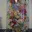 Glass dome on wooden base enclosing a floral display made entirely of dyed fish scales.