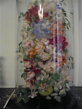 Glass dome on wooden base enclosing a floral display made entirely of dyed fish scales.