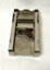 Metal, automatic razor blade sharpener with a sharpening stone, in a red leather case containing printed instructions.