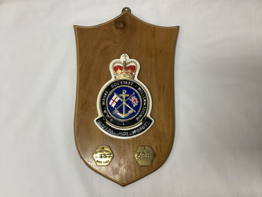HMA Naval Dockyard Williamstown plaque. The central cast iron shield is hand painted, and incorporates the Naval Dockyard motto: "Deeds not Words". Mounted on three point polished timber shield. Brass hanging point.
