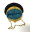 Small circular black cotton crocheted evening handbag, with a cream plastic clasp and a plastic chain link handle. The clasp has a design of four elephants and a depiction of Buddha in the centre. Peacock blue coloured silk lining, with ruched edging.