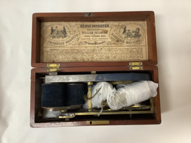 An 1890s magneto shock machine enclosed in a cedar box with instructions on the under-side of the lid. It is actuated by turning the exterior handle which is attached to two gear wheels, one of which has a cord belt that rotates a dual coil.  Metallic wires are attached to two brass handles which when held in each hand conduct the current through the body.