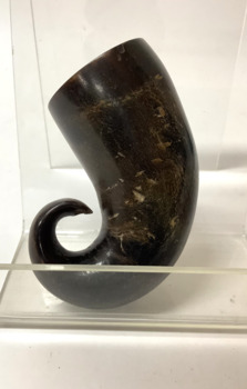 Section of curved, polished dark brown animal horn, probably from a goat or a sheep, used as a snuff container.