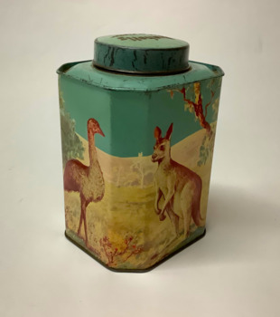 A Bushells eight-sided cylindrical tin tea caddy with a lid. Four sides are large, the other four are small. It is decorated with polychrome transfers in blue, green, yellow and grey, depicting Australian animals in  bushland setting. On the larger sides: a kangaroo, a koala, a kookaburra and an emu. 