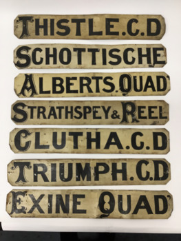 Seven double sided dance programme signs. Hand painted in black ornate capital letters on white painted metal.