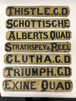Seven double sided dance programme signs. Hand painted in black ornate capital letters on white painted metal.