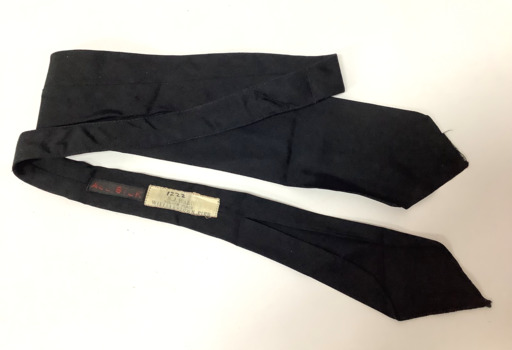 Long black silk tie with sellers label on the back - "M.J. WARD/NELSON PLACE/WILLIAMSTOWN PIER"