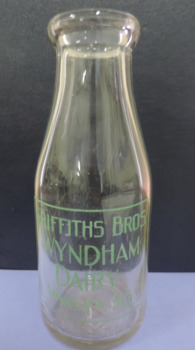 Clear glass bottle, embossed on back, stamped in green on front, "1 pint. Griffiths Bros, Wyndham Dairy"