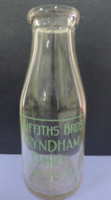 Clear glass bottle, embossed on back, stamped in green on front, "1 pint. Griffiths Bros, Wyndham Dairy"