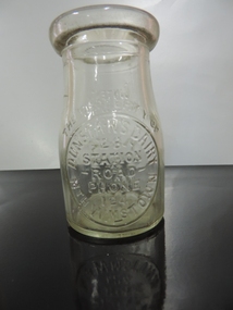 Small clear glass bottle for cream, embossed front and back, from Dunstans dairy Williamstown