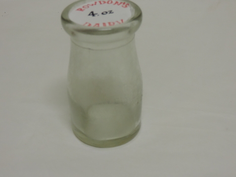 Clear glass 4oz cream bottle embossed front and back.