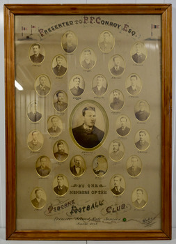 A photograph of the Osborne Football Team Williamstown, part of the Victorian Junior Football Association 1885, the year they won the premiership.  It comprises 29 small, sepia individual photographs arranged around a larger photograph of a thirtieth member of the team, P.F. Conroy to whom the framed photograph was presented. One photograph is missing from its place. The photograph has been framed in a wooden frame under glass.