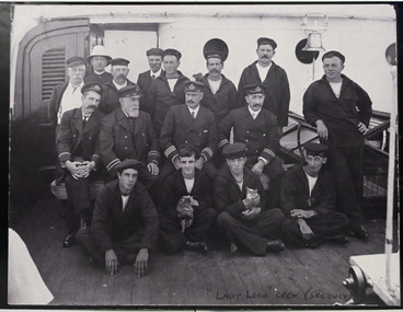 Large black and white group photograph of 16 male crew members of the 'Lady Loch', a Lighthouse Tender.
Crew shown in photograph:
BACK ROW: L to R: J.McEWan, cook; -----------------; Mr. Prince, steward;--------------------;------------------------; Mr. Nelson, fireman.
CENTRE ROW: Mr. Bradley, 2nd officer; Captain Bolger; Mr.Trace, 1st officer (later captain);-------------------.
FRONT ROW: ---------------;Clarence "chicken" Young, seaman (later father of Betty) (holding cat); Doug Geary (holding cat);------------------.