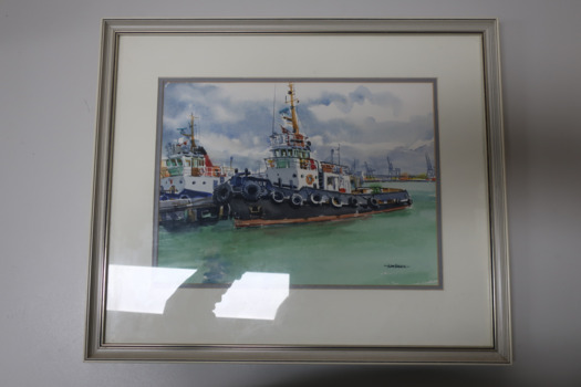 Coloured watercolour painting of two tug boats docked at Williamstown. The tug in the foreground is the "Latrobe". Dock cranes at Port Melbourne in background. Framed in a gold painted wooden frame, on a white mat. Painted by Jean Harris.