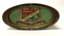 An large oval lidded tin, highly decorated with a gold filigree border, and a large scrolled product name. Main colours are red, pink, green and gold. The price for toffees is shown as 4oz for 3 1/2 d. The lid shows a large shield with a bee hive depicted. 