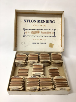 Lidded cardboard box containing 92 cards of five different coloured nylon mending thread for stockings.  