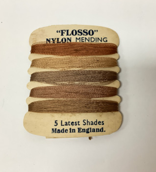 A card of coloured nylon mending thread for stockings 