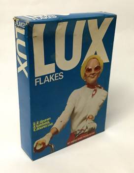 Open carton/box of LUX soap flakes - circa 1960. Box is blue showing a coloured picture of a woman smiling whilst riding a bicycle.