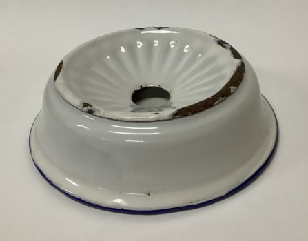 White enamel soap dish with a blue rim around the base of the bowl - an enamel insert with a large hole holds the soap and drains water into the dish. 