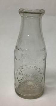 Clear glass small milk bottle with embossed inscription, from F.G. Smith's Jersey Dairy Mason St.  NEWPORT