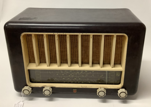 Philips brand Australian made vintage valve radio model 123  circa 1950 - 1952. Dark brown mottled bakelite case with primrose coloured grille and control knobs: volume, on/off, tone and tuning are in white bakelite with grey insets. Philips emblems are in the centre of the control knobs and on the right side the radio station numbers are displayed. 