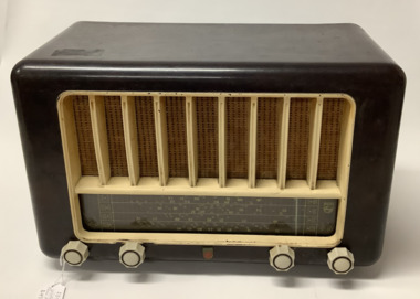 Philips brand Australian made vintage valve radio model 123  circa 1950 - 1952. Dark brown mottled bakelite case with primrose coloured grille and control knobs: volume, on/off, tone and tuning are in white bakelite with grey insets. Philips emblems are in the centre of the control knobs and on the right side the radio station numbers are displayed. 