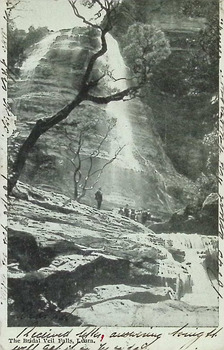 Postcard. Black and white photograph of Bridal Veil Falls, Leura, N.S.W. with a group of seven individuals standing at the base of the falls.