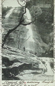 Postcard. Black and white photograph of Bridal Veil Falls, Leura, N.S.W. with a group of seven individuals standing at the base of the falls.