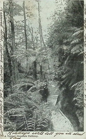 Postcard. Black and white photograph of a mountain pathway with person with a pack and hat on walking.