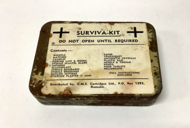 'Surviva-Kit' in an lidded tin box, containing a range of items that would help survival, such as matches, fishing line and hook, and medical items. The tin box has a list of the items printed in black font on a paper label on the lid.