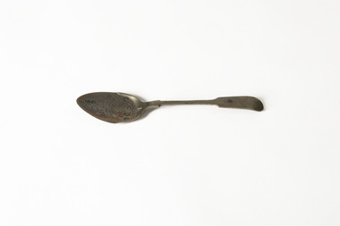 A silver spoon featuring floral motif on the head
