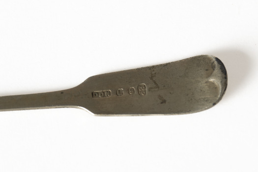 A silver spoon featuring floral motif on the head