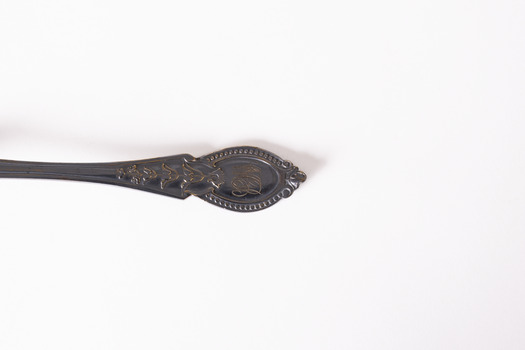 Rear view of teaspoon with tarnished patina. 