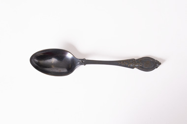 Rear view of teaspoon with tarnished patina. 