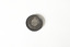 Front side of a small, round, dark-coloured medal depicting an agricultural country scene in the background. In the foreground there is a woman in a toga holding up a wreath. 