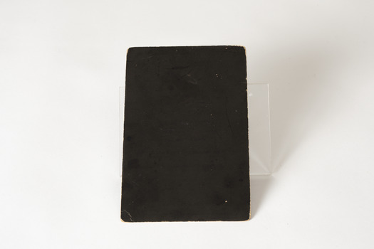 Small brown card with writing in a shade of gold. There is an angel in the top left corner, the name Frederick Buse in the center with a decorative boarder around the name and passages from the bible in the top right corner and under his name and information