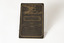 Small brown card with writing in a shade of gold. There is an angel in the top left corner, the name Frederick Buse in the center with a decorative boarder around the name and passages from the bible in the top right corner and under his name and information