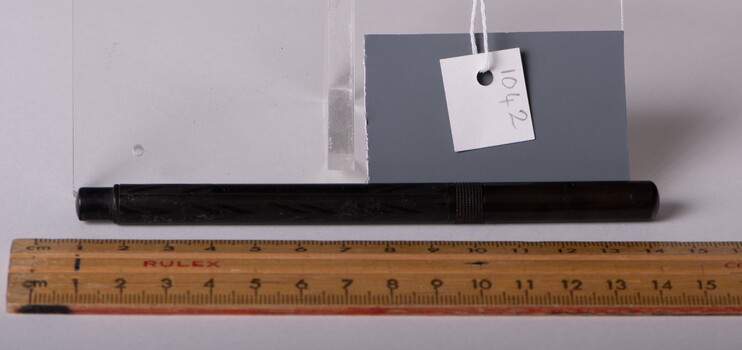 A solid and complete black patterned fountain pen. Measurement ruler and object label are also present.
