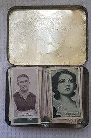 Cigarette cards in a tobacco tin