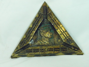 Brass triangle featuring embossed image/bust of Sir John Monash in the centre of triangle.