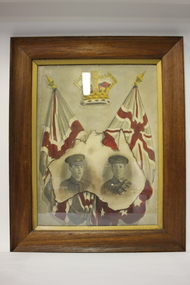 Timber frame containing image of two soldiers within a map of Australia below a crown and two flags.