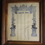 Brown timber frame containing document listing four columns of names within two pillars and scrolled heading