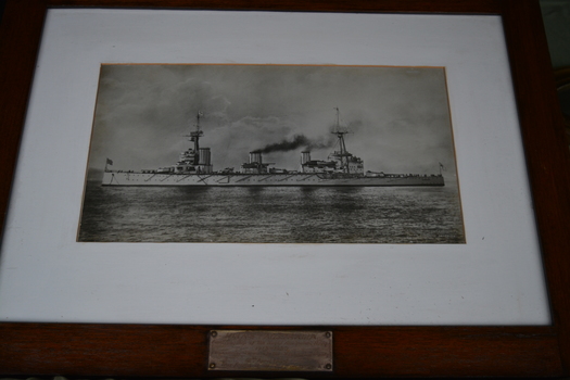 Timber frame of black and white print of a ship at sea.