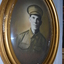 Gold coloured oval frame with sepia photograph of WW1 Soldier wearing cap