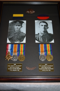 Timber frame with rising sun badge, two coloured patches, two photographs of soldiers and  5 medals