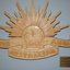 Carved timber emblem in the shape of the Rising Sun above crown and scroll
