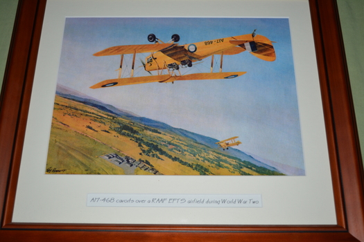 Brown timber frame containing print of aircraft flying upside down